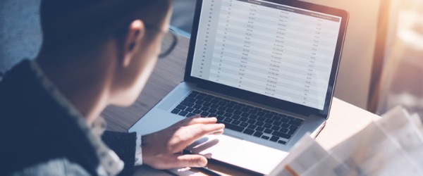 An underwriter on his computer evaluating and determining an individual's approval for coverage.