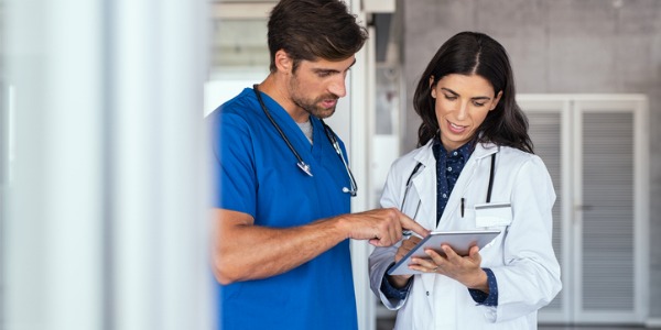 A physician assistant and a physician discussing patient files.