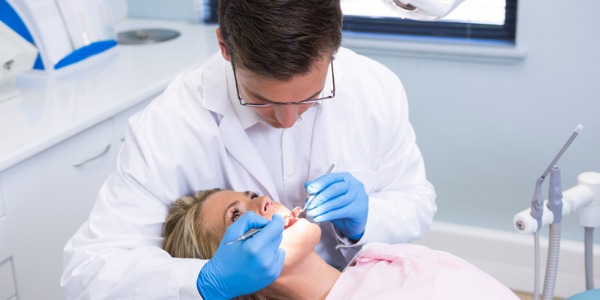 A dentist checking a patient's mouth.