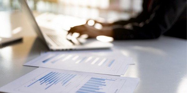 An investment fund manager working on financials at his desk.