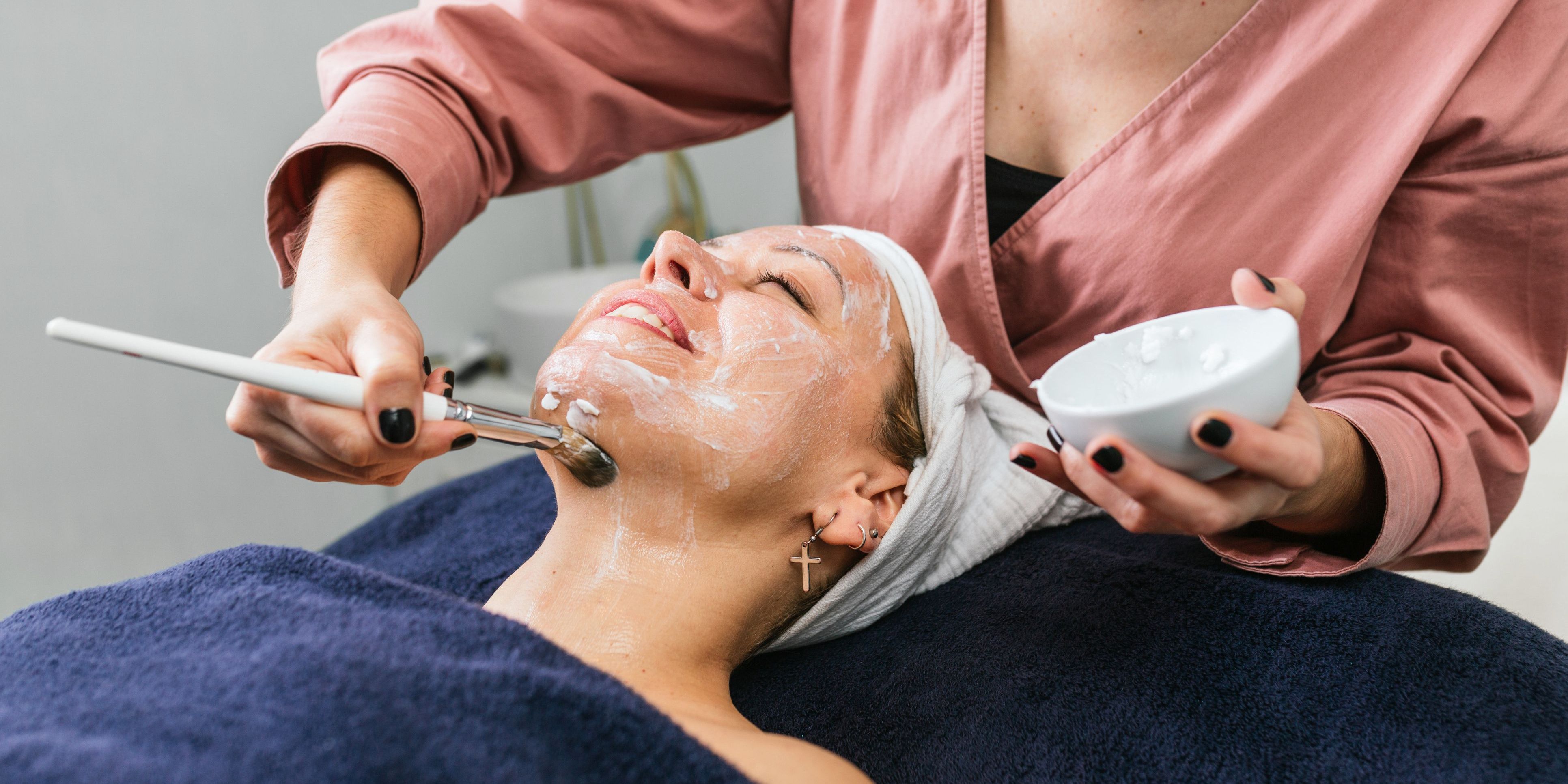 An anti-aging skincare specialist applying a facial treatment on a client.