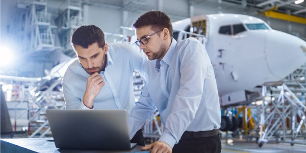 Two aerospace engineers looking at designs.