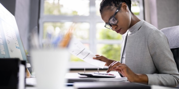 An auditor sitting at her desk, assessing a company's financial records.